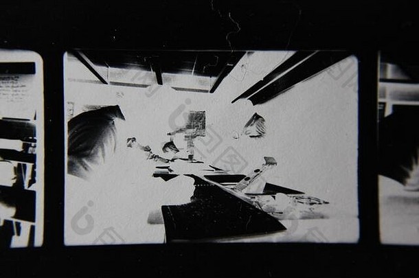 精美的70年代复古隐形打印黑白极端照片，一名学生在教室里做手写笔记。