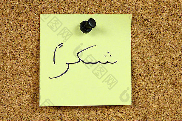 办公室软木公告板上的黄色小便条。阿拉伯语中的shukran一词，意思是谢谢你。