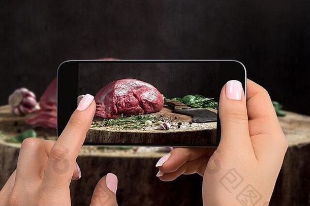 一位年轻女子用智能手机拍摄食物，用手机拍摄食物