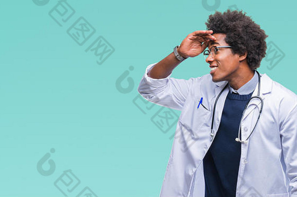 非裔美国医生男人在孤立的背景下非常高兴，微笑着看着远处，手放在头上。<strong>搜索</strong>概念。