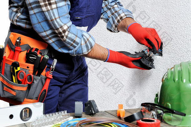 手戴手套和绝<strong>缘</strong>工具的电工在住宅电气装置中遵守安全规<strong>定</strong>。