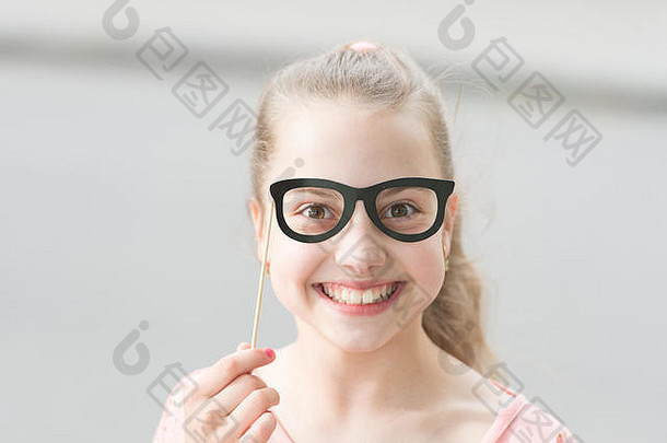给每个孩子一个快乐的童年。可爱的小孩，笑容可掬，通过眼镜道具看起来很有趣。夏日快乐的小女孩，笑容满面。国际儿童节快乐。