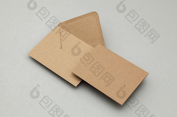 灰色背景上的空白棕色牛皮纸卡片和信封
