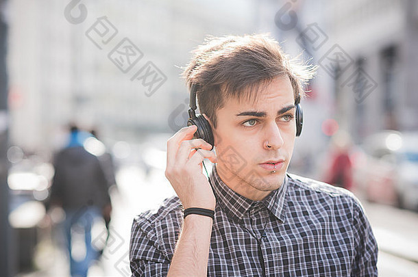 年轻英俊的另类黑人模特儿戴着耳机和智能手机<strong>无线上网</strong>听音乐