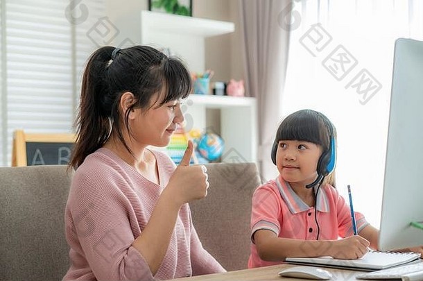 亚洲女孩<strong>学生</strong>妈妈。拇指女儿视频会议电子学习老师电脑生活房间首页在家上学
