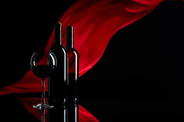 葡萄酒杯瓶红色的酒黑色的反光背景红色的缎窗帘收敛了风焦点前景复制空间
