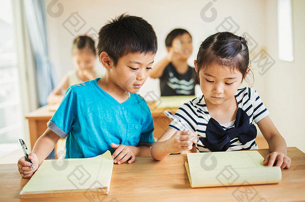 一群孩子在教室里，男孩和女孩一起工作。