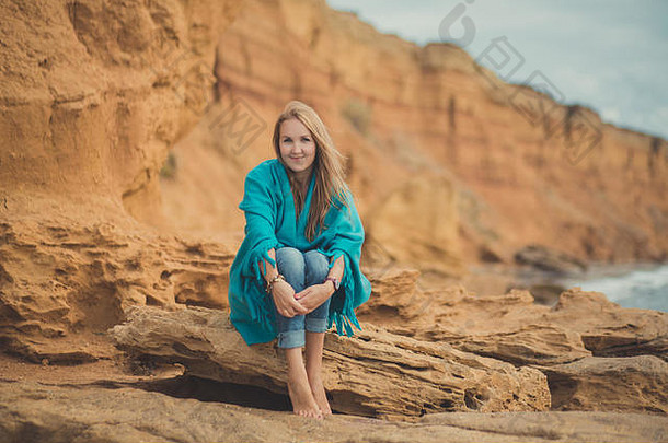 可爱的美女女士伊芙穿着时髦的蓝色牛仔裤衬衫和带有触感的大帽子，独自一人在海边的海边度假