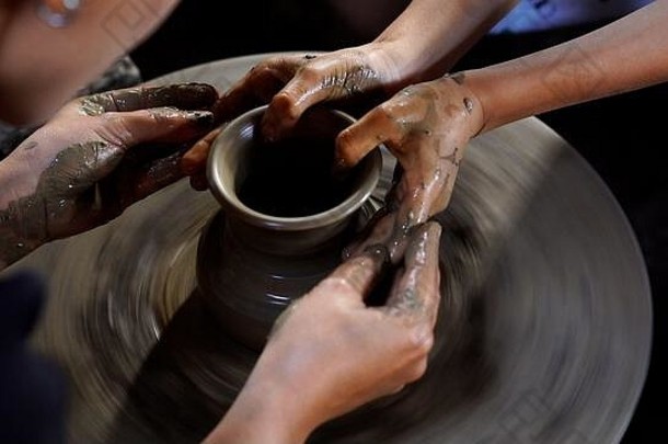 陶工之手正在陶工轮上制作一个陶制的罐子或花瓶