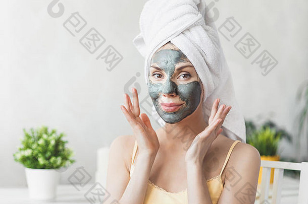 脸皮肤护理有吸引力的年轻的女人包装浴毛巾应用粘土泥面具脸皮肤护理概念女孩采取护理肤色