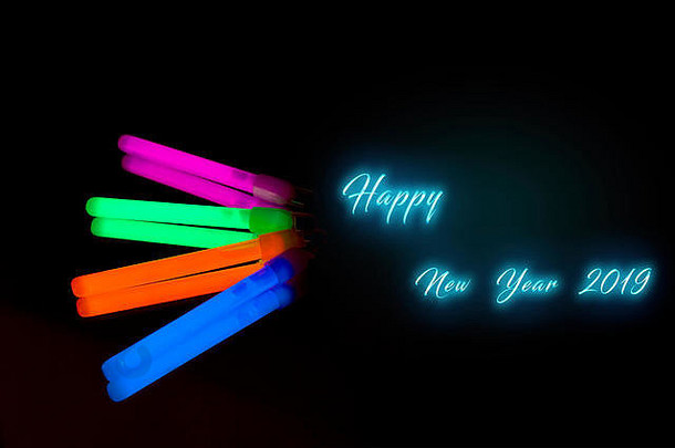 快乐一年色彩斑斓的荧光光霓虹灯发光坚持镜子反射黑色的背景蓝色的粉红色的橙色绿色大发光棒
