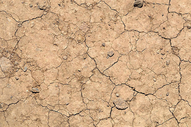 从上面看，干燥的土壤表面有裂缝。气候变化和全球变暖的环境标志背景
