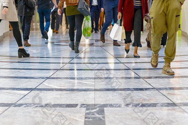 一个现代的地板，背景是一个购物中心里行走的人群的腿