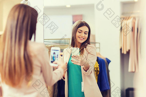 在商店用智能手机拍摄镜子自拍的女人
