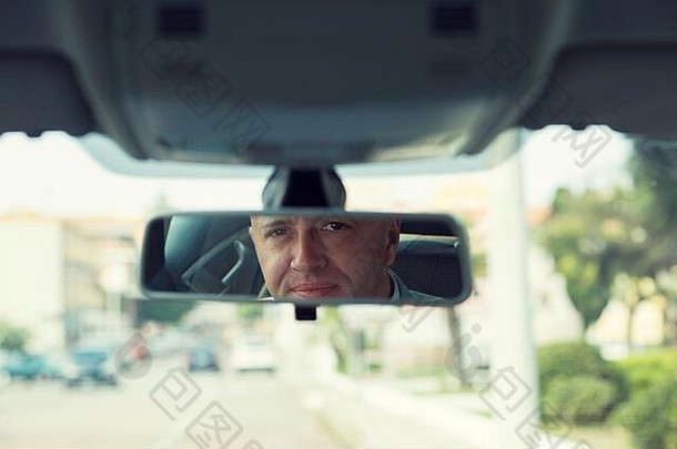 英俊的业务男人。司机坐着前面座位车相机后镜子