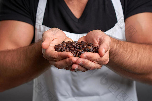 咖啡豆在一个年轻的咖啡师手里。