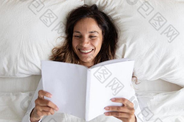 快乐混合比赛年轻的女人享受阅读书床上