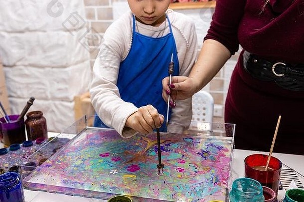 Ebru工作室的大师班-水上绘画艺术。女教师教6岁女孩Ebru技术