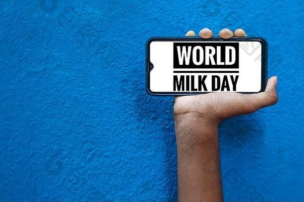 6月1日-智能手机手机屏幕上的“世界牛奶日”字样，蓝色背景上显示“隔离”。世界牛奶日措辞。