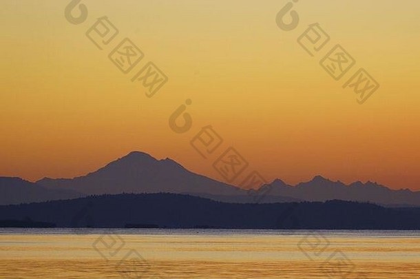 日出前的片刻贝克山和喀斯喀特山脉矗立在海湾和圣胡安群岛后面。