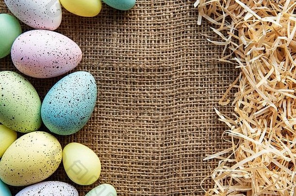 麻布和稻草上的复活节彩蛋。复活节快乐彩蛋。背景是复活节彩蛋。平面布置，俯视图。
