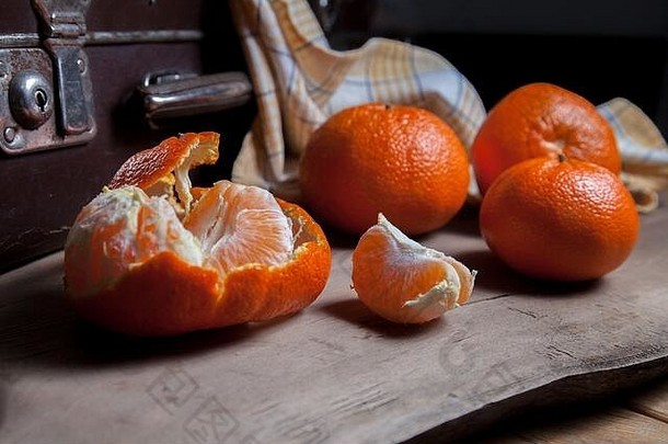 几种未去皮的全新鲜柑橘或柑橘、柑橘、克莱门汀、柑橘类水果，其中一种是半去皮的水果和去皮的人的切片