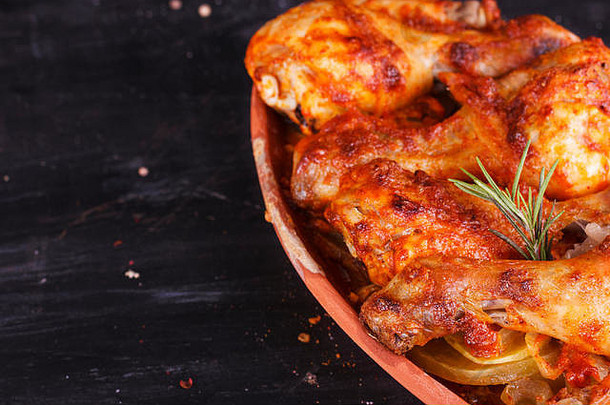 红辣椒酱鸡肉在烤箱中用粘土锅盘烘烤。鸡腿鸡翅