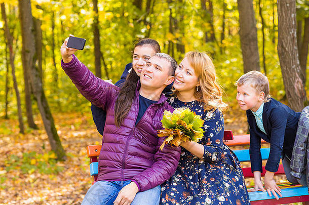 家庭童年季节技术人概念快乐家庭拍摄秋天公园