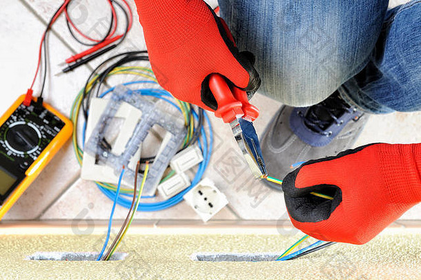 电工技术员在住宅电气装置的电缆上使用钳子