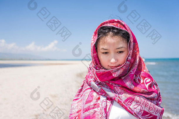 在海边戴红帽子的亚洲女人