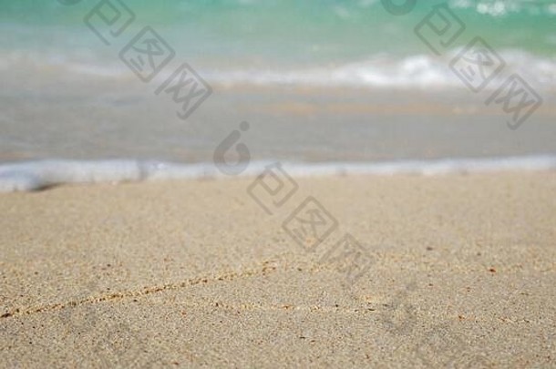 白色沙滩上蓝色海洋的柔和波浪。夏季背景。