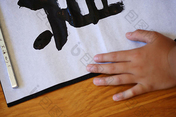 在一张纸上用日语书写的儿童手的高角度视图