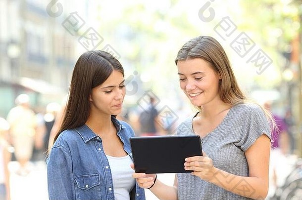 两个朋友站在街上观看平板电脑在线内容