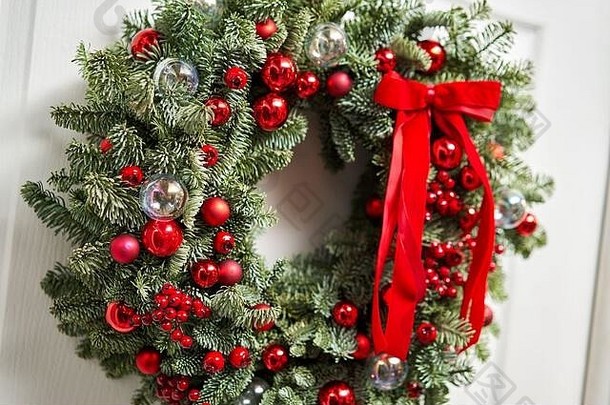 美丽的红色的圣诞节花环新鲜的云杉白色通过入口房子圣诞节情绪圣诞节树