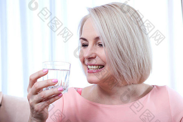 肖像画美丽的中年妇女早晨喝水