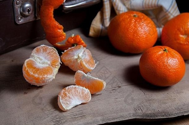 几种未去皮的全新鲜柑橘或柑橘、柑橘、克莱门汀、柑橘类水果，其中一种是半去皮的水果和去皮的人的切片