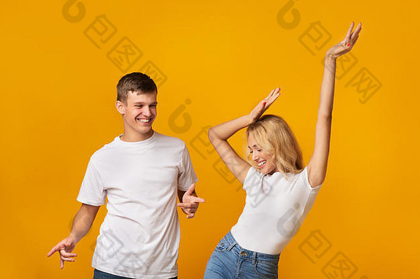 在演播室里，一对幸福的年轻夫妇在黄色<strong>背景</strong>下一起跳舞