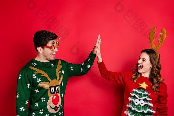 有趣的两人家庭的侧面照片棕色头发的丈夫给high five享受<strong>主题派对</strong>穿舒适的圣诞树设计毛衣