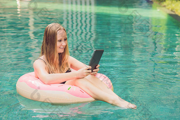 年轻的女自由职业者坐着池移动PC酒店浏览智能手机忙假期遥远的工作概念复制