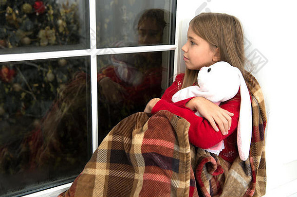 享受温暖。带着兔子<strong>玩具</strong>的小孩看窗户。小女孩在家里过圣诞节。小女孩抱着<strong>玩具</strong>朋友。小孩在圣诞节放松一下。圣诞快乐，新年快乐。