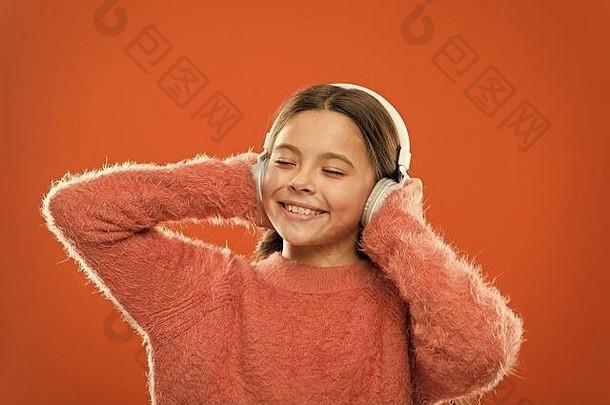 让外面的噪音更安静，音乐听起来更好。小女孩用悠扬的声音放松。可爱的孩子戴着耳机听音乐。小孩子喜欢用耳机播放电子声音。