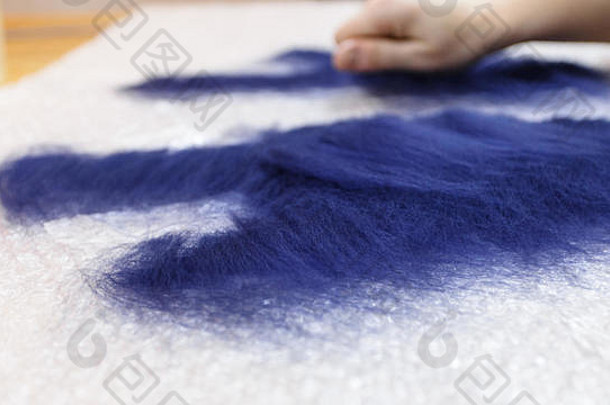手工制作羊毛手套的车间，采用湿毡工艺，由蓝色美利奴羊毛制成，切割图案特写部分覆盖一层纤维