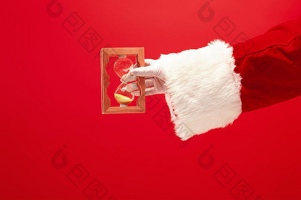 圣诞老人持有沙子时钟红色的背景季节冬天假期庆祝活动礼物概念