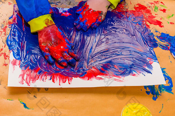 用彩色<strong>颜料画</strong>的孩子的手。教育、学校、创意和绘画理念。模糊的软焦点