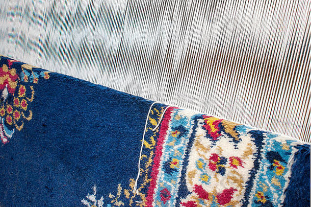 部分机织地毯，织机上的地毯显示羊毛桩、基础、经纱和纬纱。