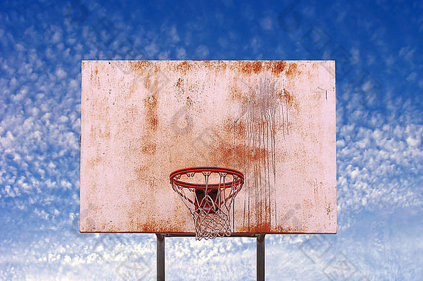 在一个城市公园的蓝天上发现了一个篮球圈，其中包括一条小路