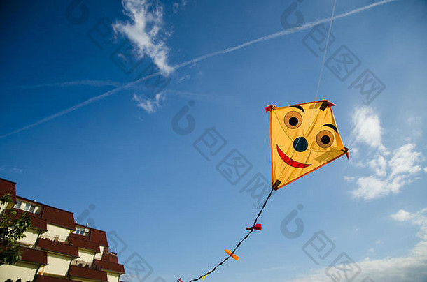 五颜六色的快乐微笑的风筝在蓝天上高飞