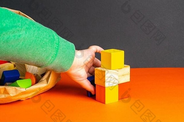一个孩子在橙色背景上玩木头方块