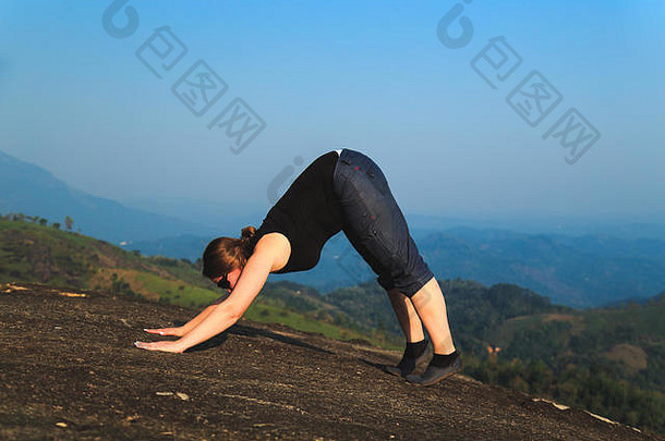 女人练习瑜伽在户外美丽的山景观概念健康的生活方式