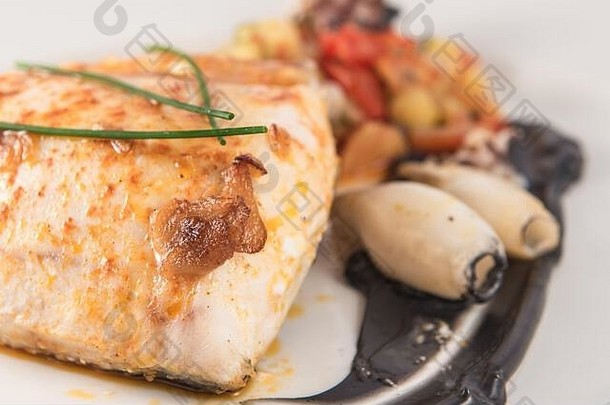 一盘烤鳕鱼，墨汁中有鱿鱼和韭菜。